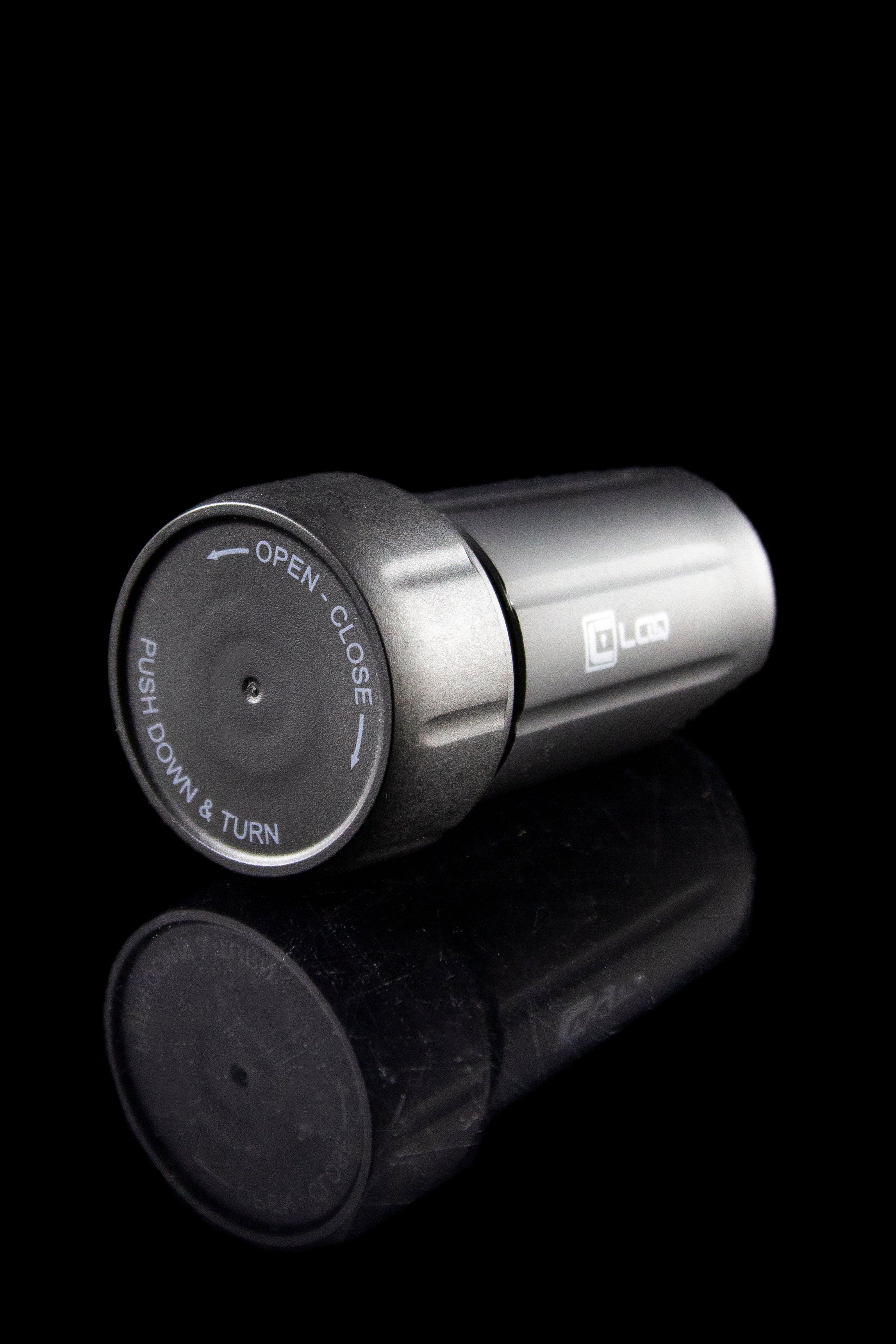 Close-up of a cannabis oil cartridge with a twisting, child-resistant cap, and a partially visible cartridge body.