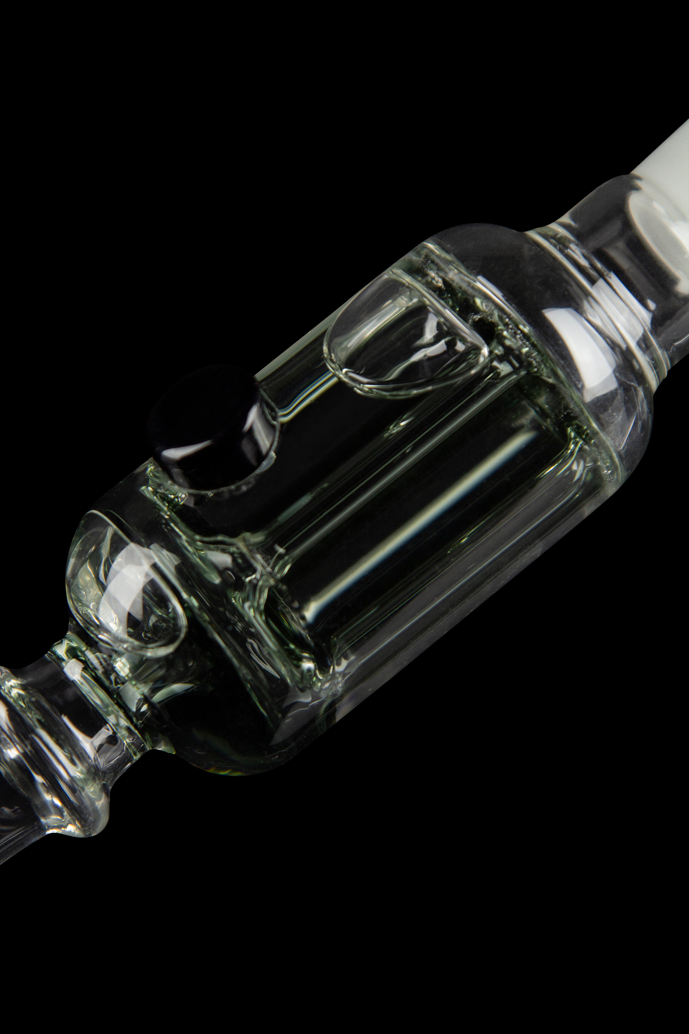 Clear glass bubbler with intricate swirling design, isolated on black.