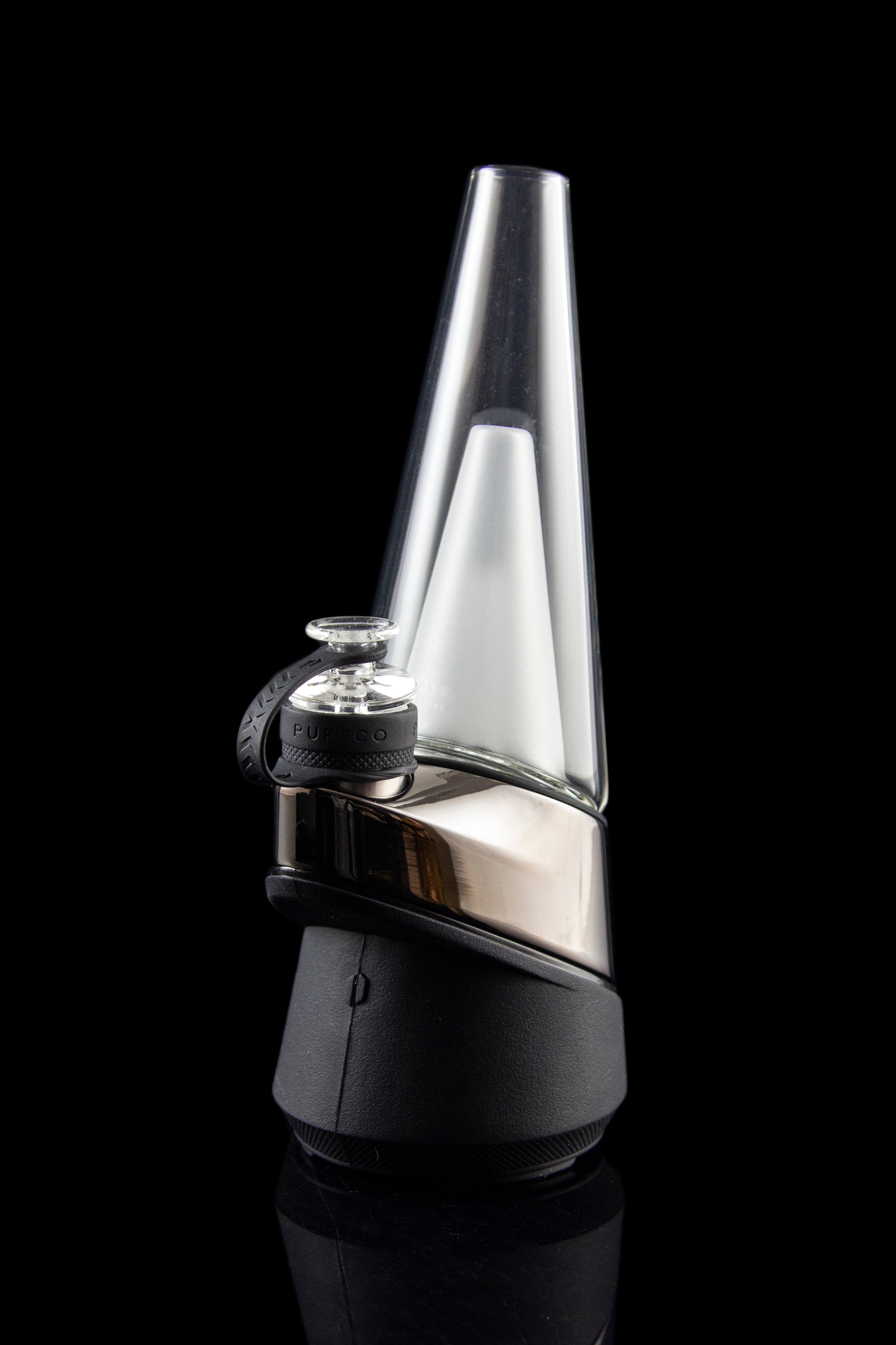 Sleek, black and silver cannabis e-rig vaporizer with a glass water pipe attachment, displayed on a reflective surface.