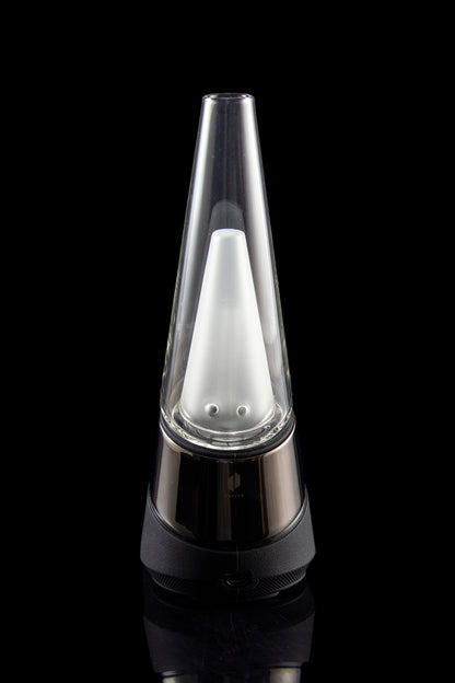 A Peak portable cannabis vaporizer with a glass mouthpiece emitting a visible vapor cloud, set against a black background.