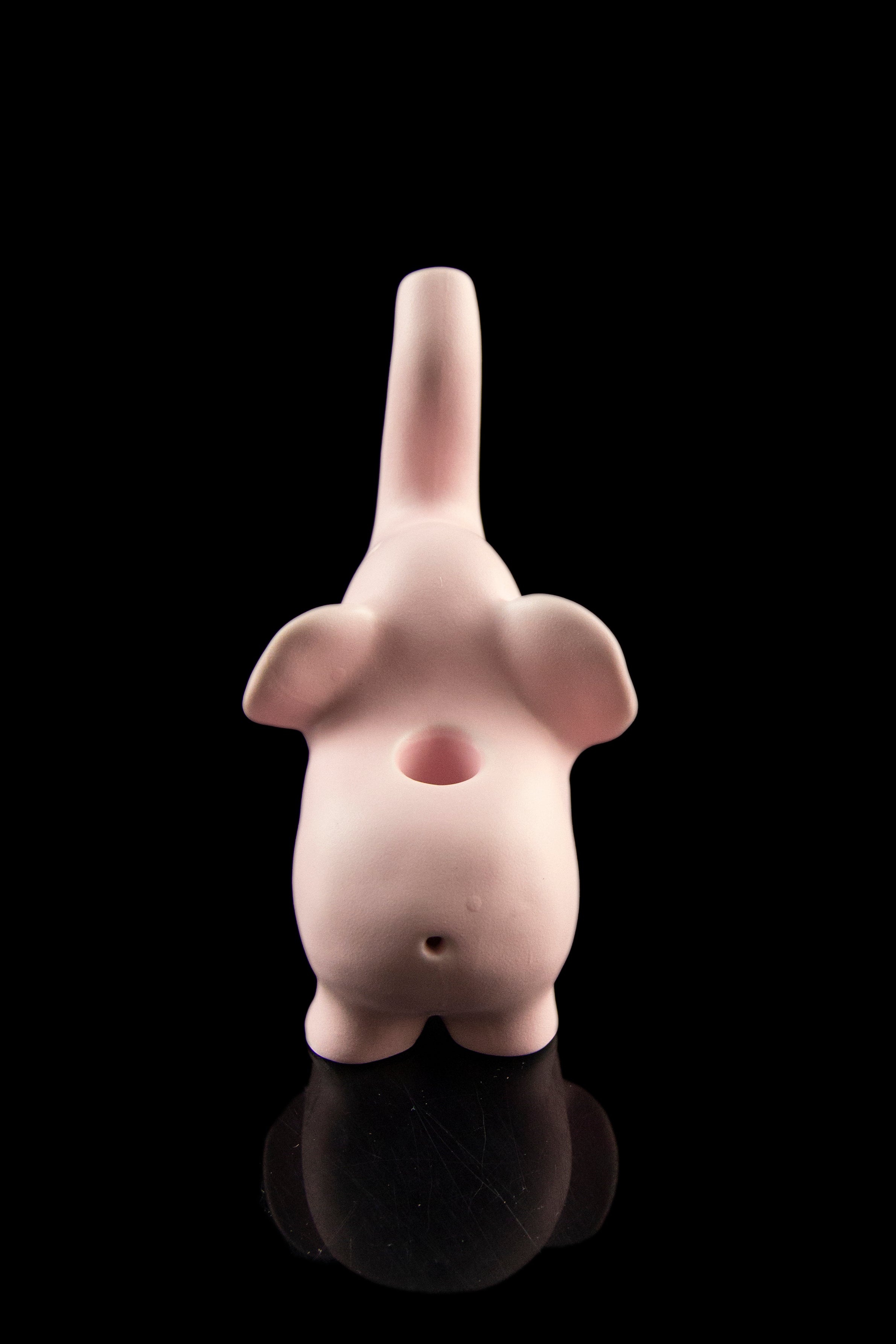 Pink ceramic water pipe shaped like a stylized, abstract figure with a glossy reflective base.