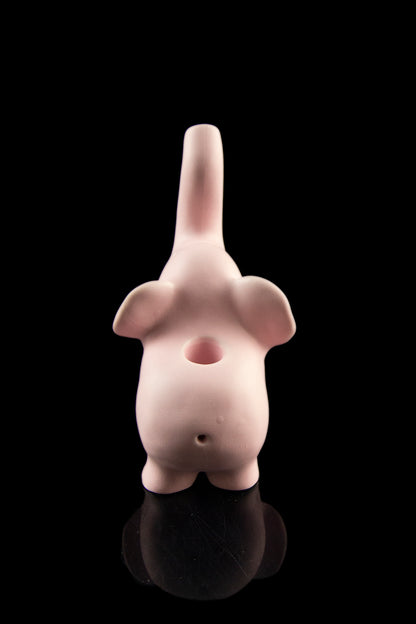Pink ceramic water pipe shaped like a stylized, abstract figure with a glossy reflective base.