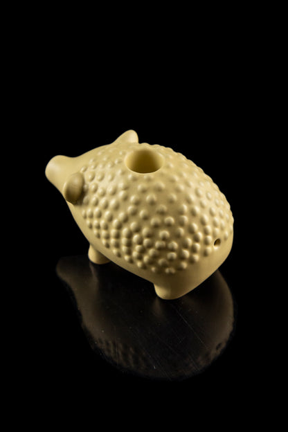 Ceramic pipe shaped like a hedgehog with a glossy finish, displayed against a black background.