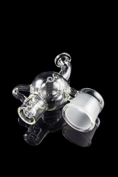 Clear glass rig with intricate bubbler design, isolated on a black background.