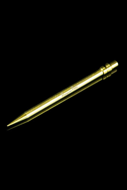 Gold cannabis dab tool on black background.