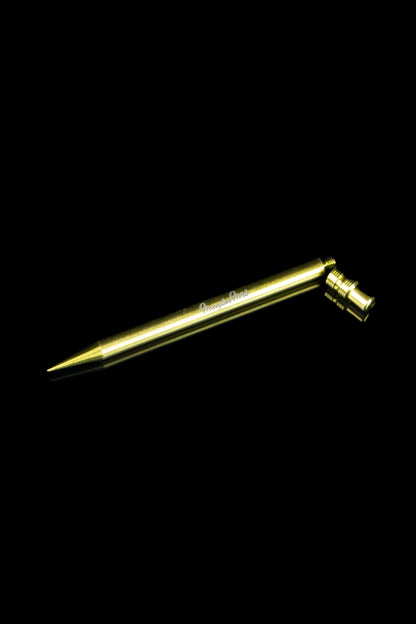 Gold-colored dab tool for cannabis concentrates against a black background.