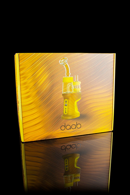 Gold packaging for a Daab cannabis concentrate vaporizer, reflected on a glossy surface.