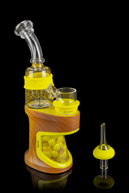 Orange and yellow electronic dab rig with glass water pipe and quartz banger.