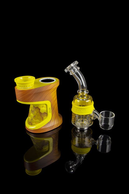 A portable electronic dab rig with a glass water pipe attachment and quartz banger, displayed on a reflective black surface.