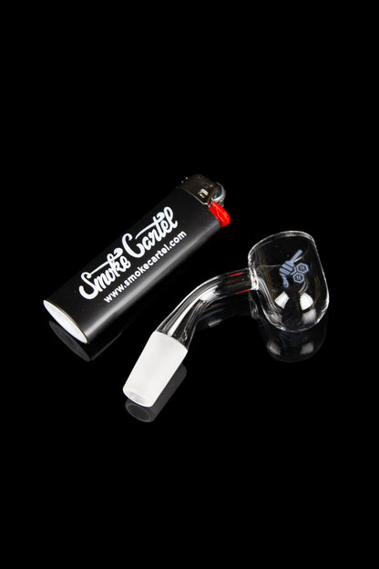 Glass dab rig with a quartz insert and torch lighter on a black surface.