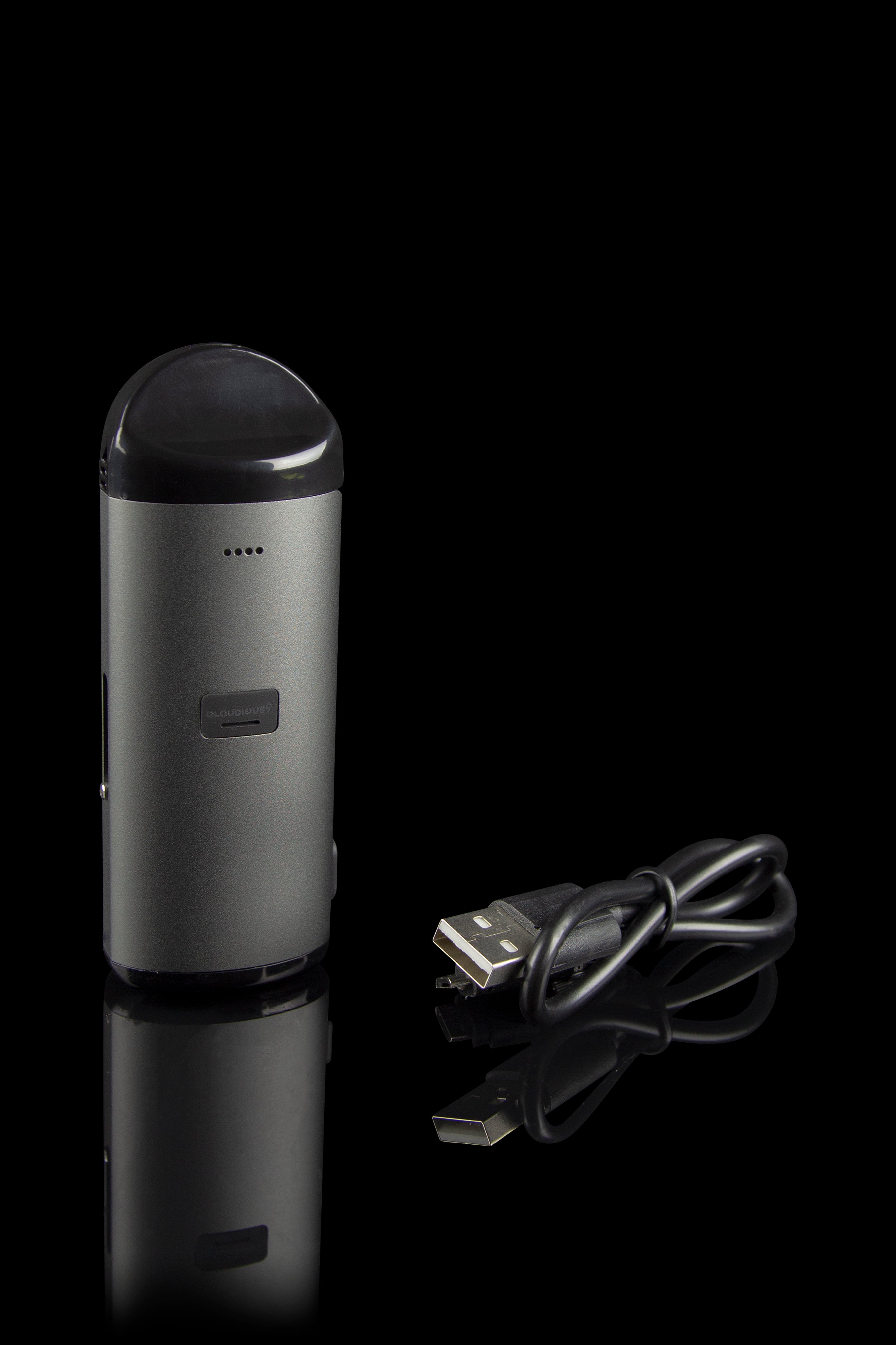 Sleek, metallic cannabis vaporizer pen with a USB charging cable, displayed on a reflective black surface.