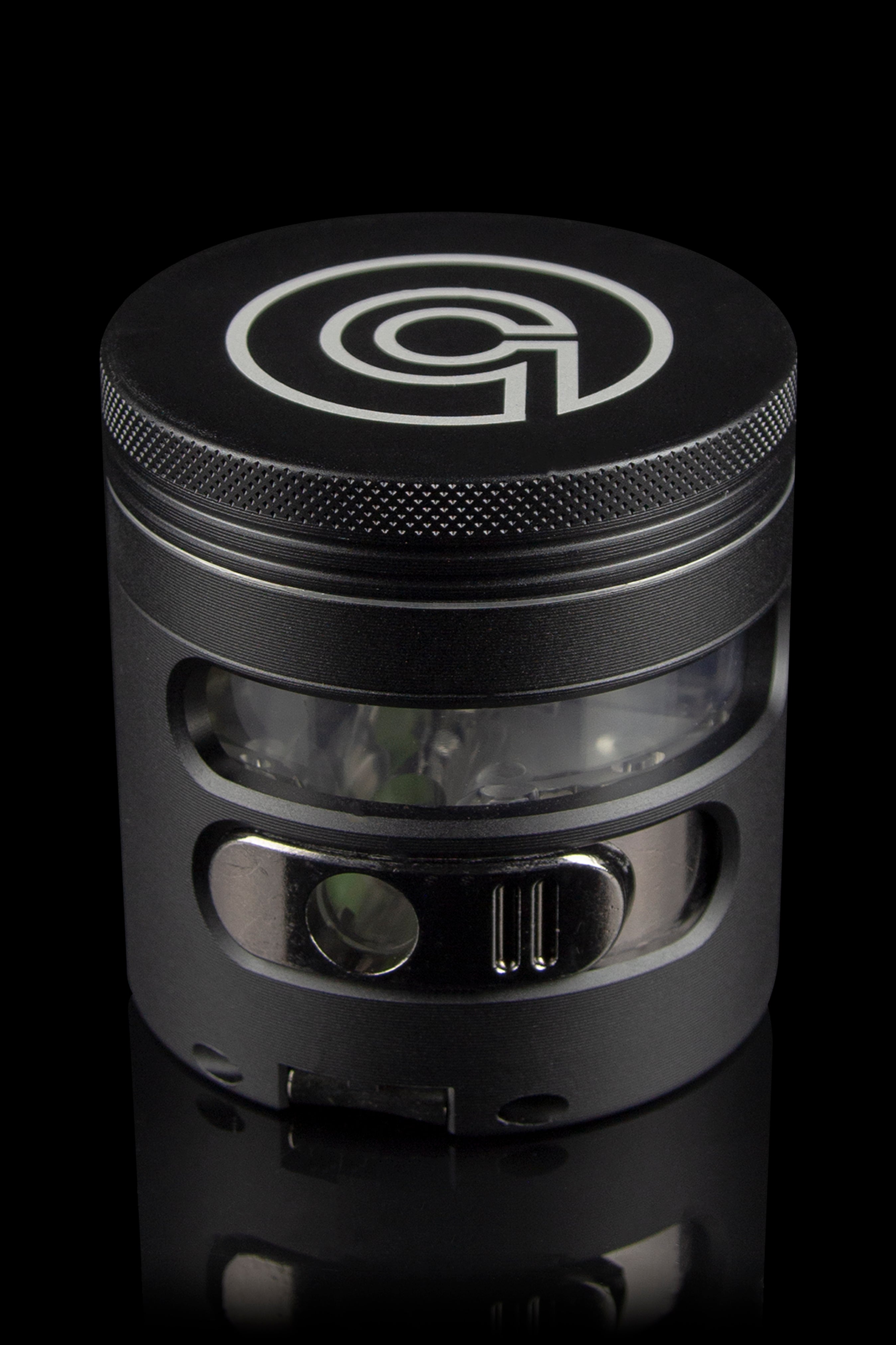 Black metal cannabis grinder with a clear viewing window, showcasing ground plant material inside."