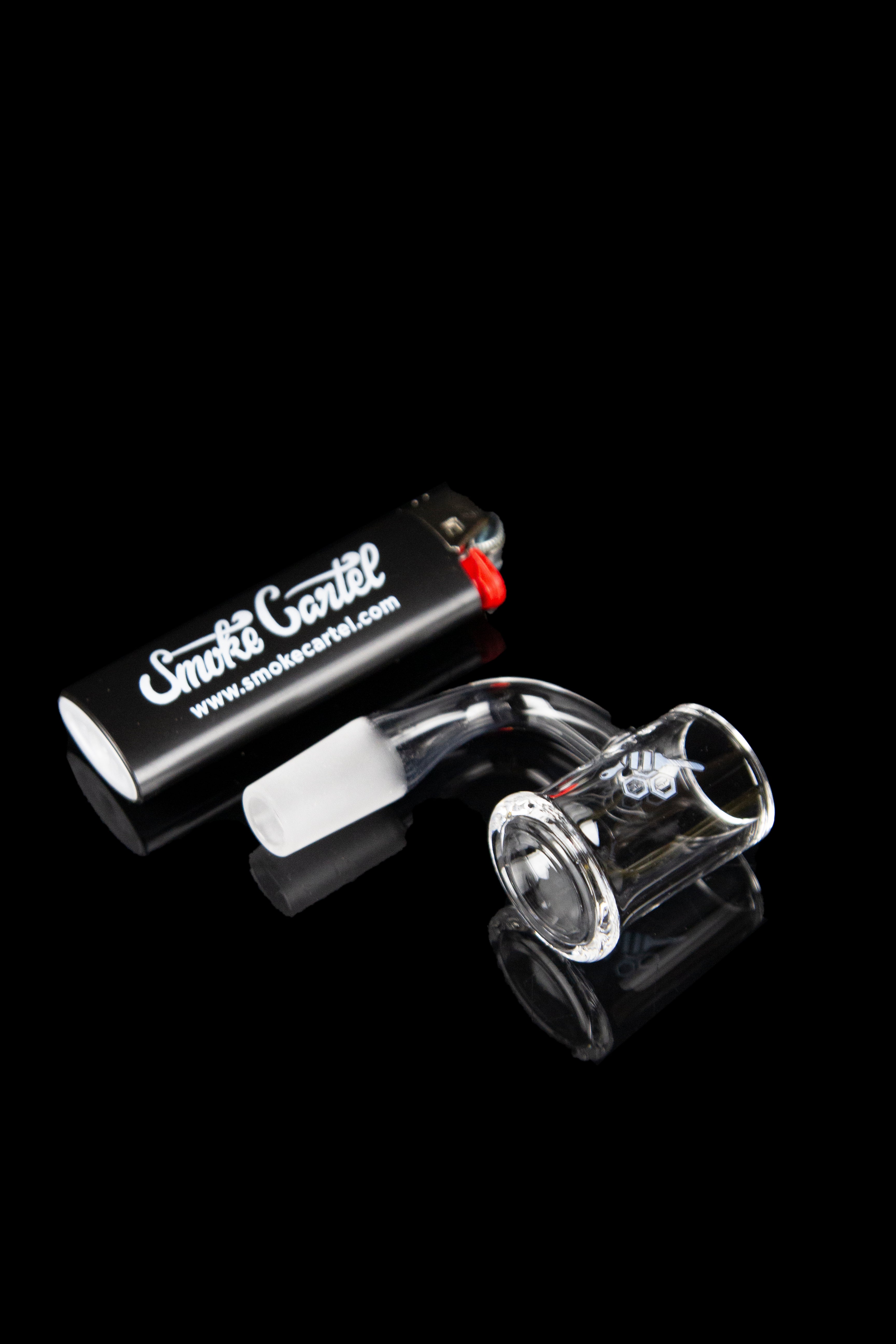 Glass bowl and metal case with “Smoke Cartel” branding on a reflective black surface.
