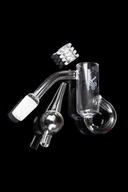 Clear glass dab rig with attachments, including a bowl, carb cap, and nail, against a black background.
