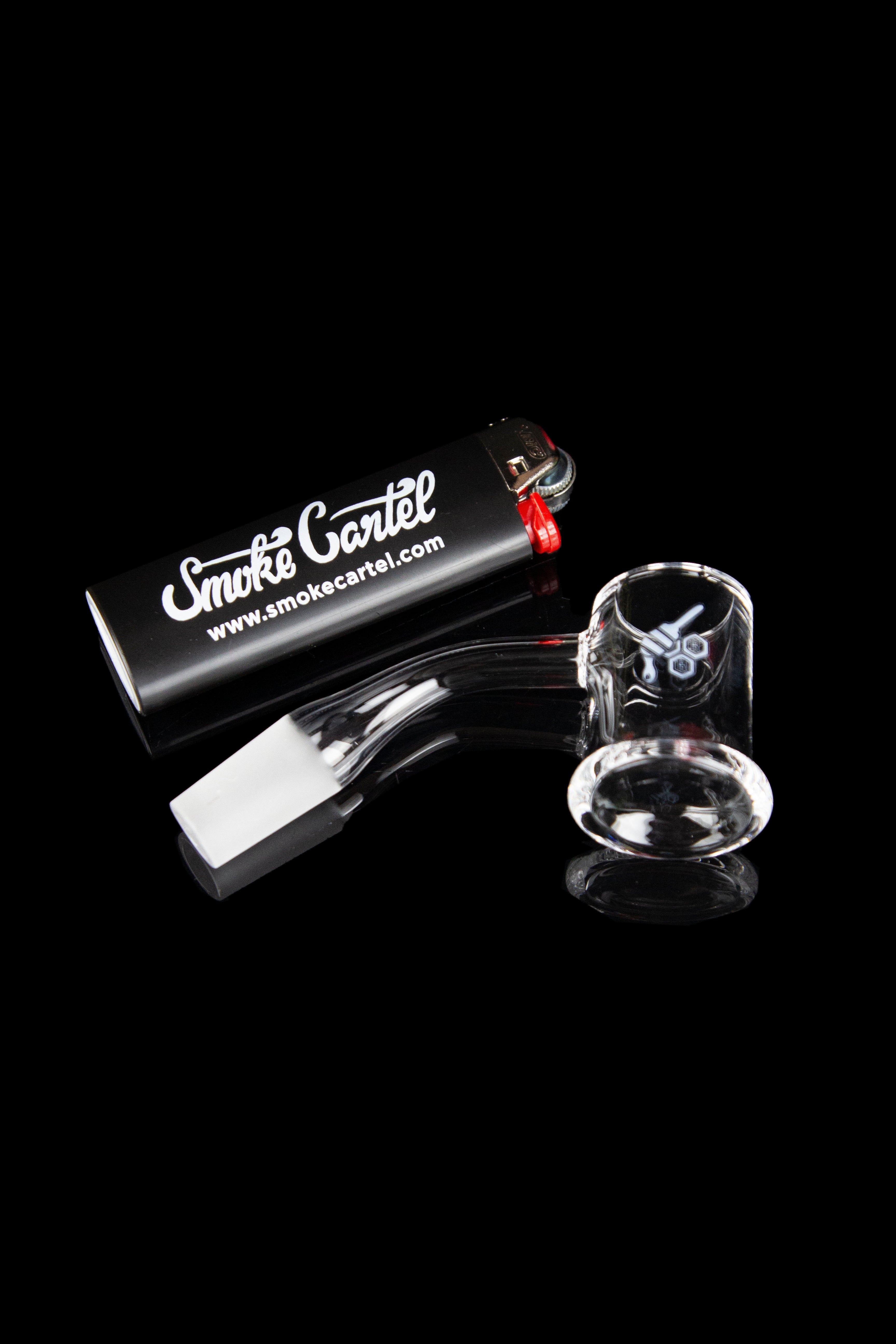 Glass bubbler pipe and accessories displayed on a black reflective surface with branded packaging.
