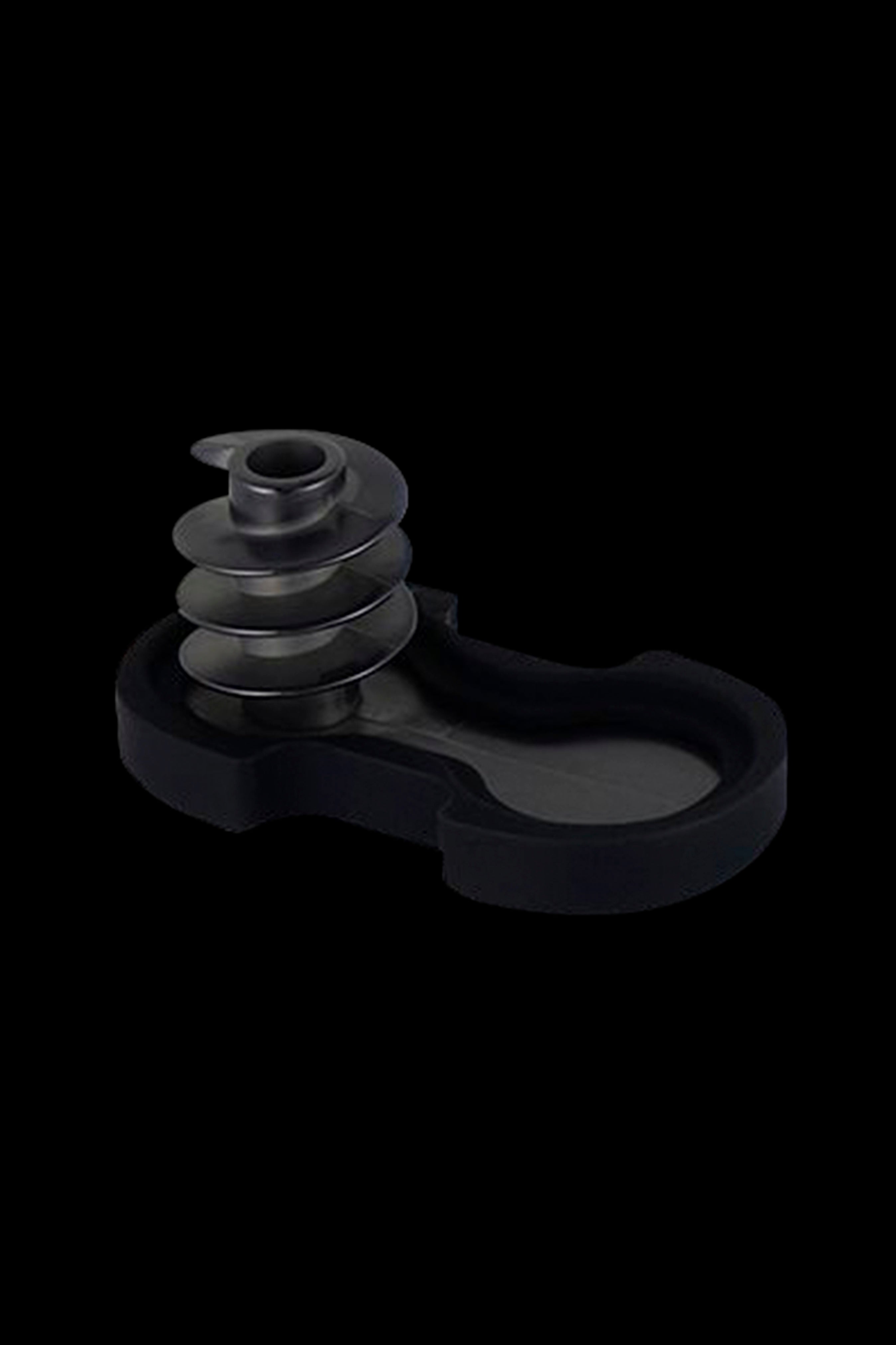 Black cannabis concentrate coil and collection dish on a dark background.