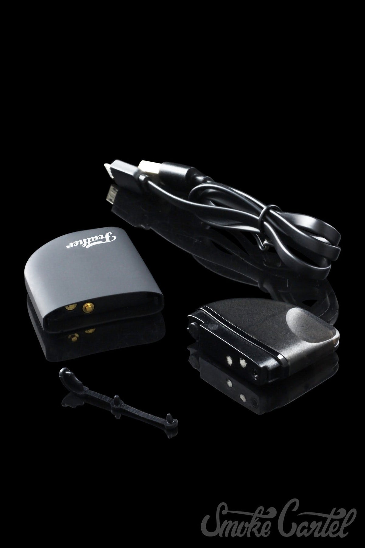 A close-up of the Kandy Pens Feather Compact Vaporizer with a sleek, dark design and a charging cable connected to its side.