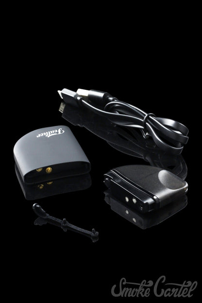 A close-up of the Kandy Pens Feather Compact Vaporizer with a sleek, dark design and a charging cable connected to its side.