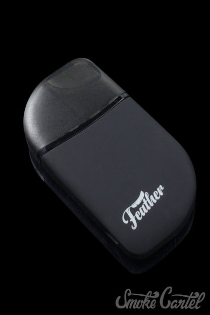 A sleek, angled studio shot of the Kandy Pens Feather Compact Vaporizer, showcasing its minimalist design on a dark background.