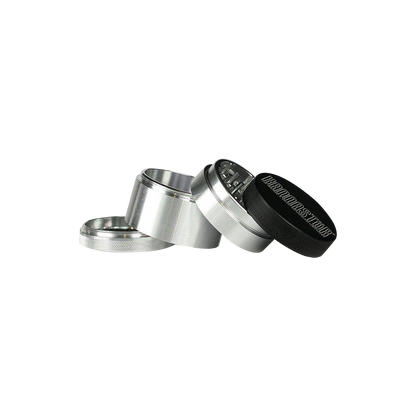 A slightly angled view of the disassembled 4-piece Kannastor Solid Body Grinder, showcasing its metallic components.