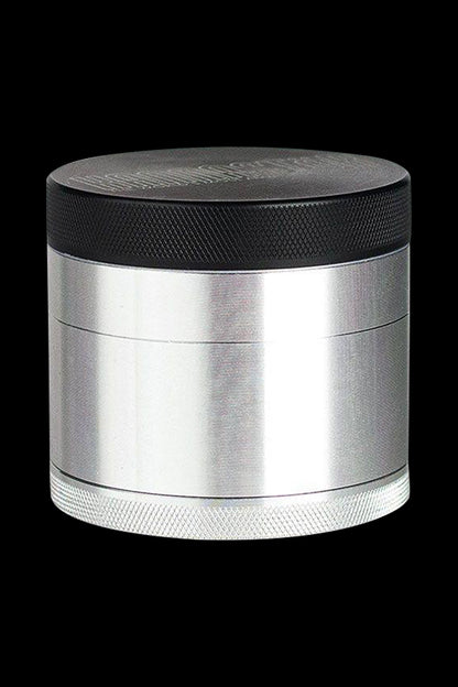 A studio shot of the Kannastor 4-Piece Solid Body Grinder, showcasing its metallic finish and four-part construction from a slightly angled view.