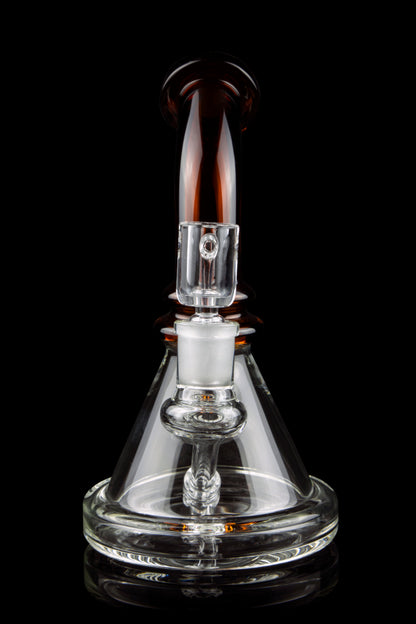 Clear glass dab rig with amber accents, isolated on a black background.
