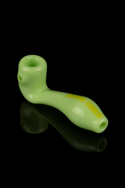 Lime green glass pipe with embossed text, reflecting on a black surface.