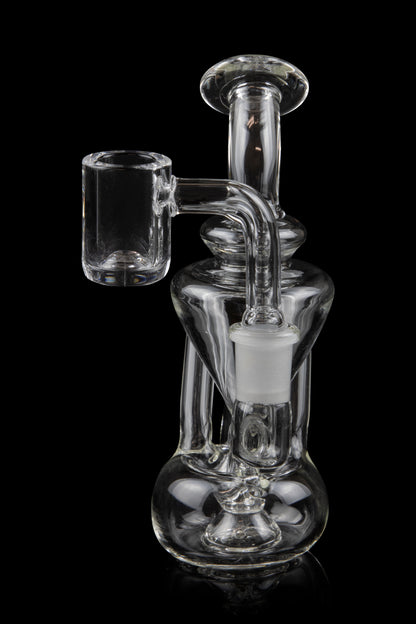 Clear glass dab rig with a quartz banger, isolated on a black background.