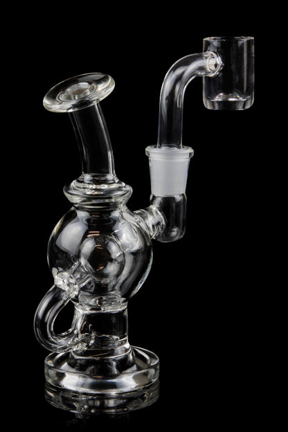 Clear glass dab rig with quartz banger, isolated on black.