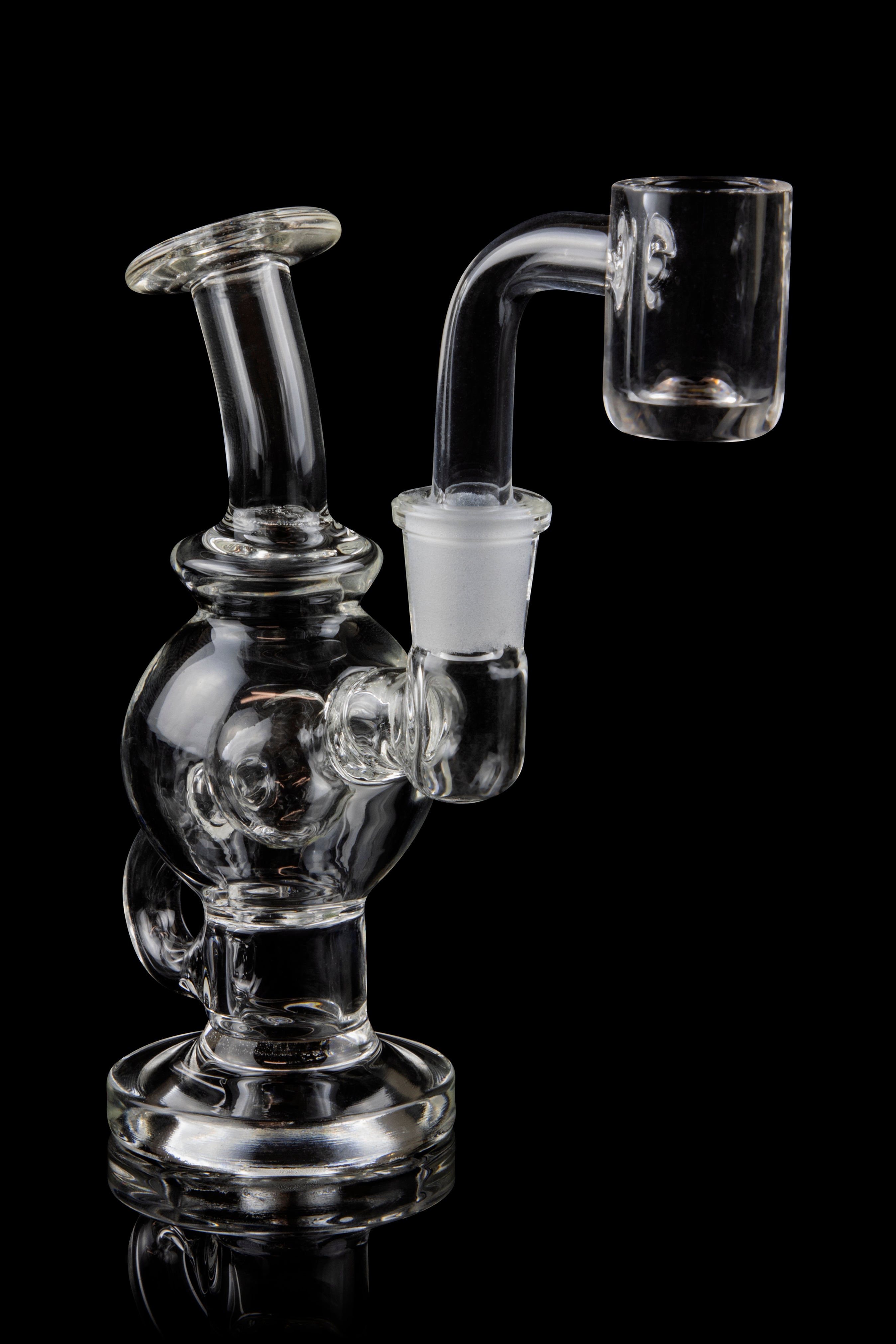 Clear glass dab rig with a quartz banger, isolated on a black background.