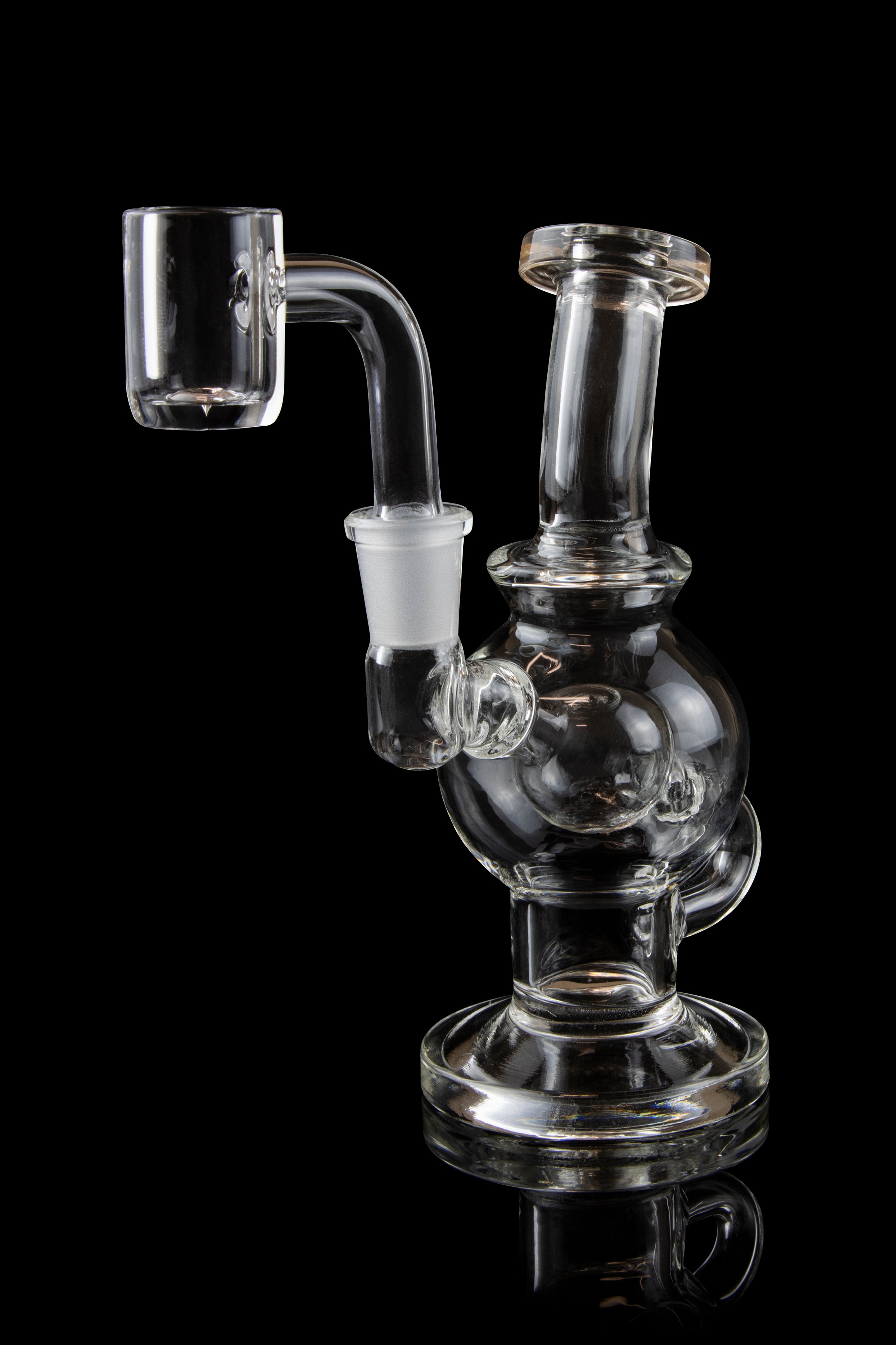 Clear glass dab rig with a quartz banger, isolated on a black background.