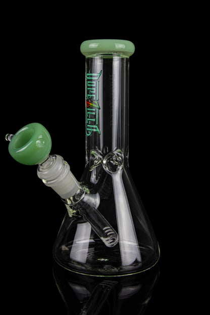 Green and black glass bong with a bowl piece, studio shot.