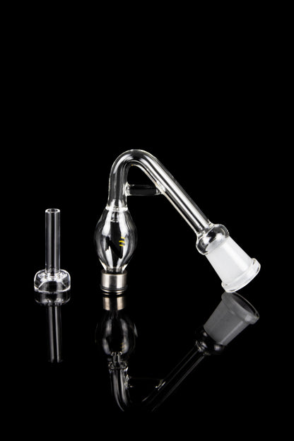 Clear glass bubbler and oil rig attachment on a reflective black surface.