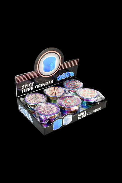 A box displays a 6-pack of Mandala Anodized Grinders, showcasing their colorful, patterned tops in a diagonal arrangement.