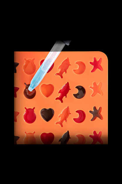 Silicone mold with cannabis-themed shapes and a dab tool.