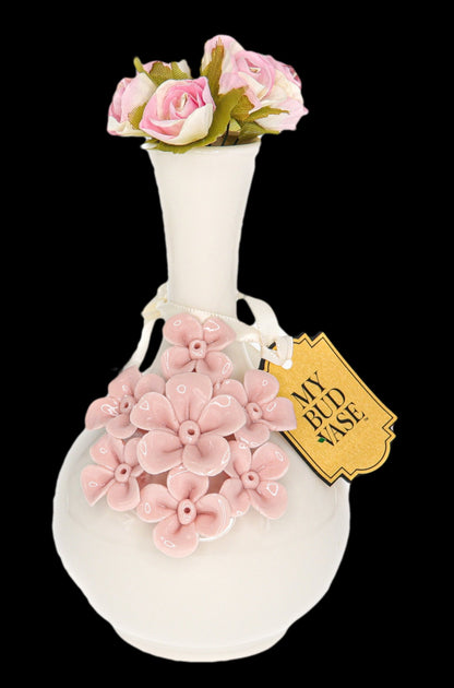 Ceramic vase shaped like a vintage perfume bottle, decorated with sculpted pink flowers and tagged “My Bud Vase.”