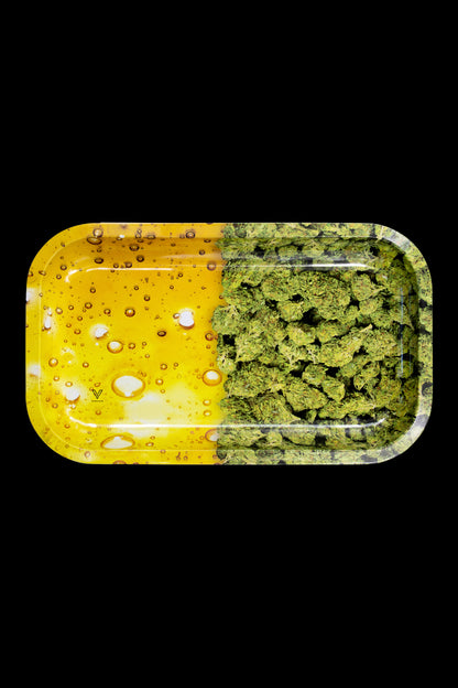 Cannabis buds and golden oil concentrate displayed on a yellow rolling tray.