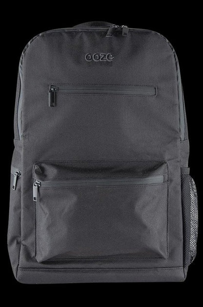 Front view of the Ooze Smell Proof Backpack, a dark-colored bag with a zipper pocket against a plain, dark background.