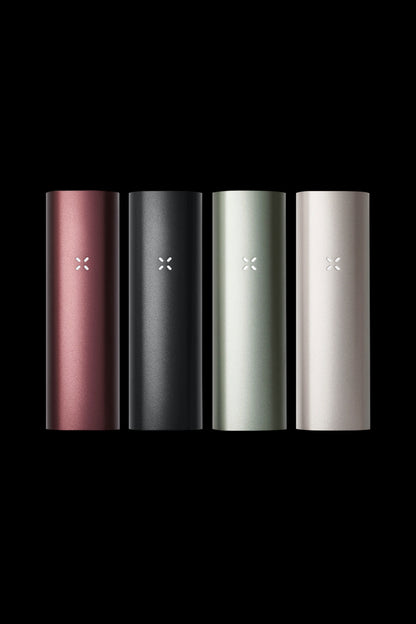 Four Pax Plus vaporizers in rose gold, black, sage green, and silver stand against a black background.