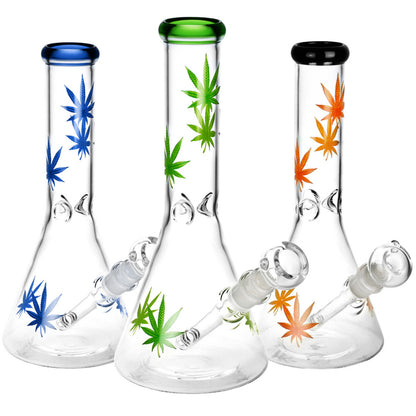 Three glass bongs with cannabis leaf designs and colored mouthpieces.