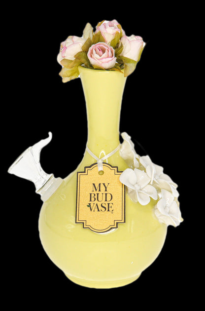 Yellow glass water pipe (“Bud Vase”) decorated with pink roses against a black background.