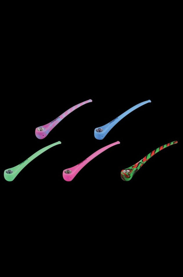 A close-up, angled view of the PieceMaker Konjurer silicone pipe, showcasing its curved shape and smooth texture against a dark background.