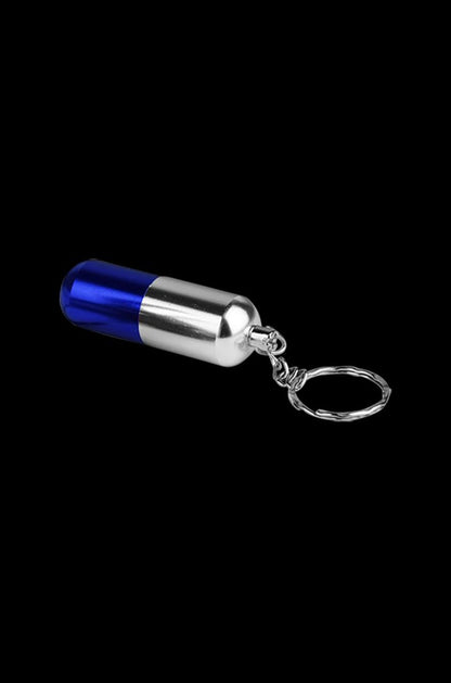 Angled close-up of a blue-and-silver Pill Transformer Metal Hand Pipe keychain against a black background.