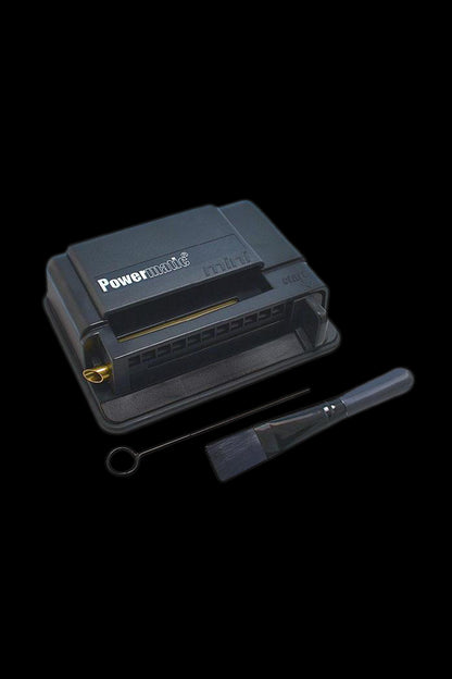 Black Powermatic cigarette rolling machine with open tray and cleaning tool.