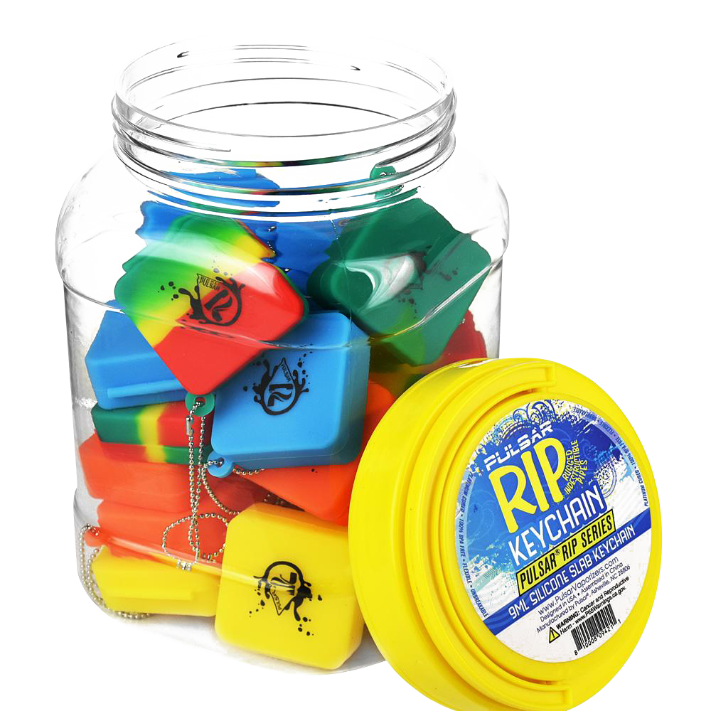 A bulk assortment of colorful Pulsar Silicone Dab Slab Containers is displayed in a top-down view, highlighting the vibrant mix of colors and simple shapes.