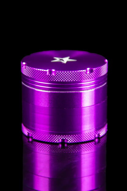 A close-up, angled view of the silver Famous X 4-Piece Grinder, showcasing its metallic texture and multi-tiered design.