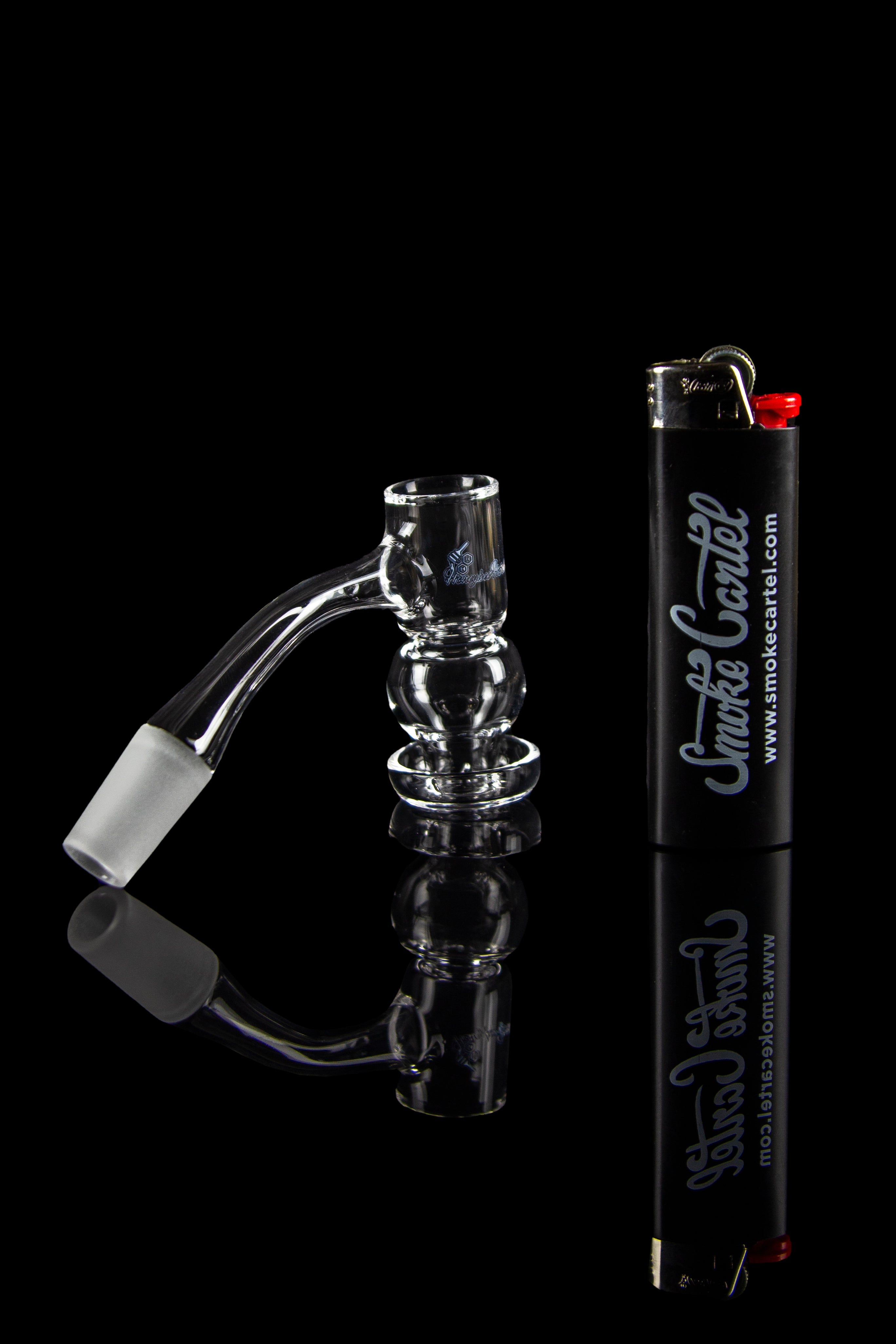Glass dab rig with accessories and lighter, on a black background.