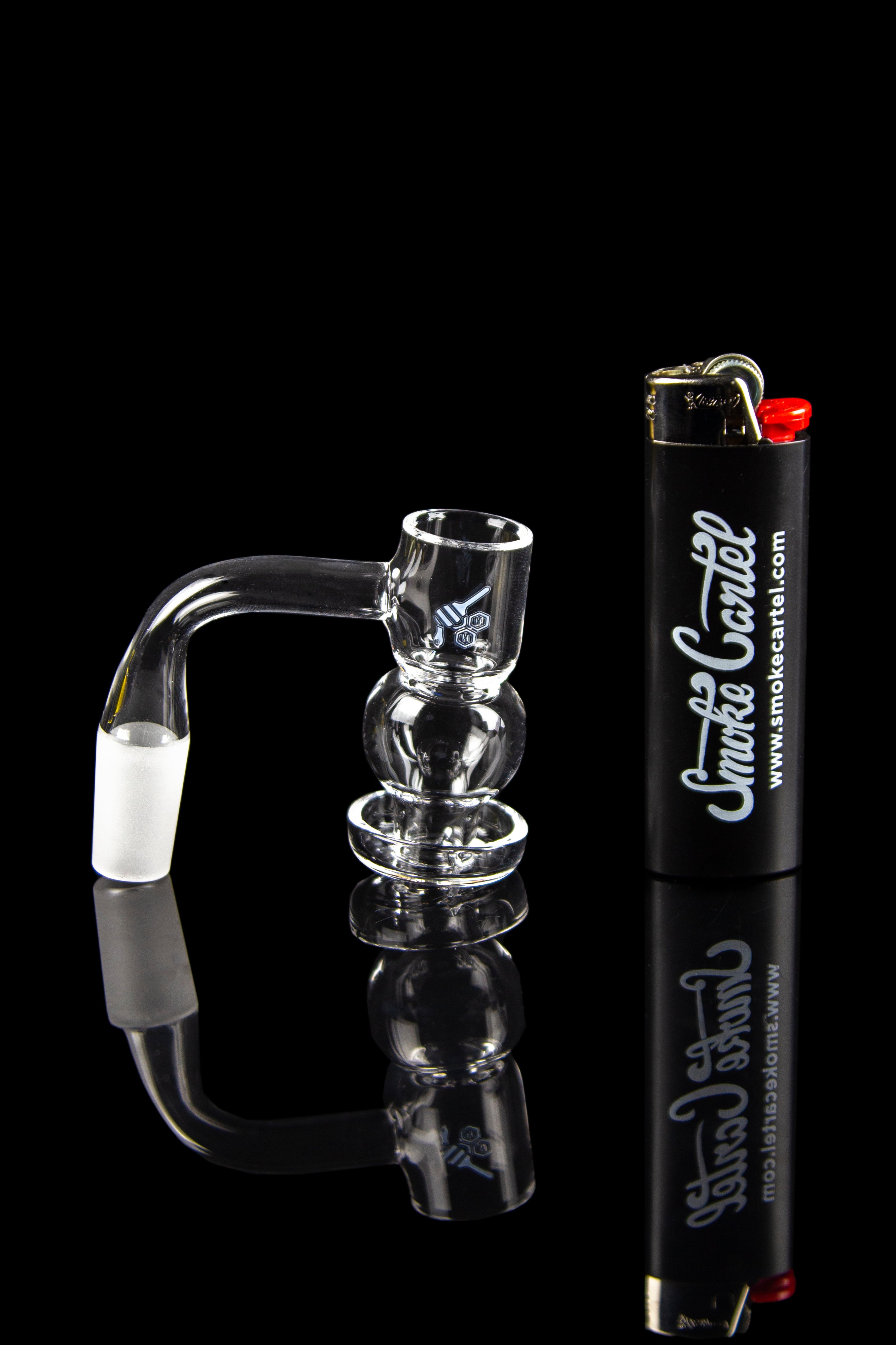 Clear glass dab rig with a lighter and branding for Smoke Cartel.