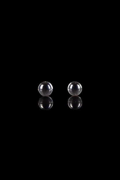 Two glass marbles against a black background, likely for use in a water pipe or dab rig.