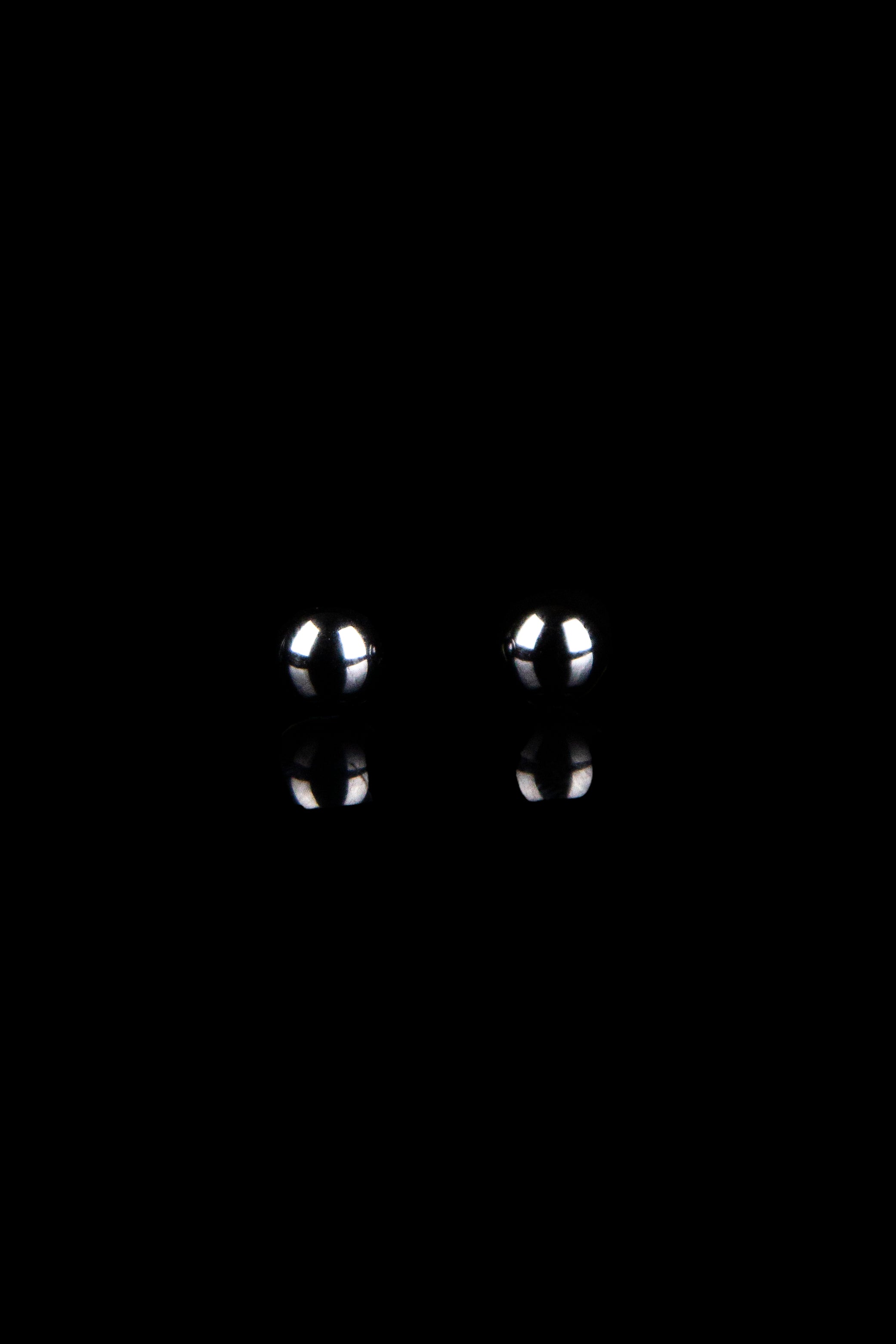 Two glass cannabis bowl screens against a black background.